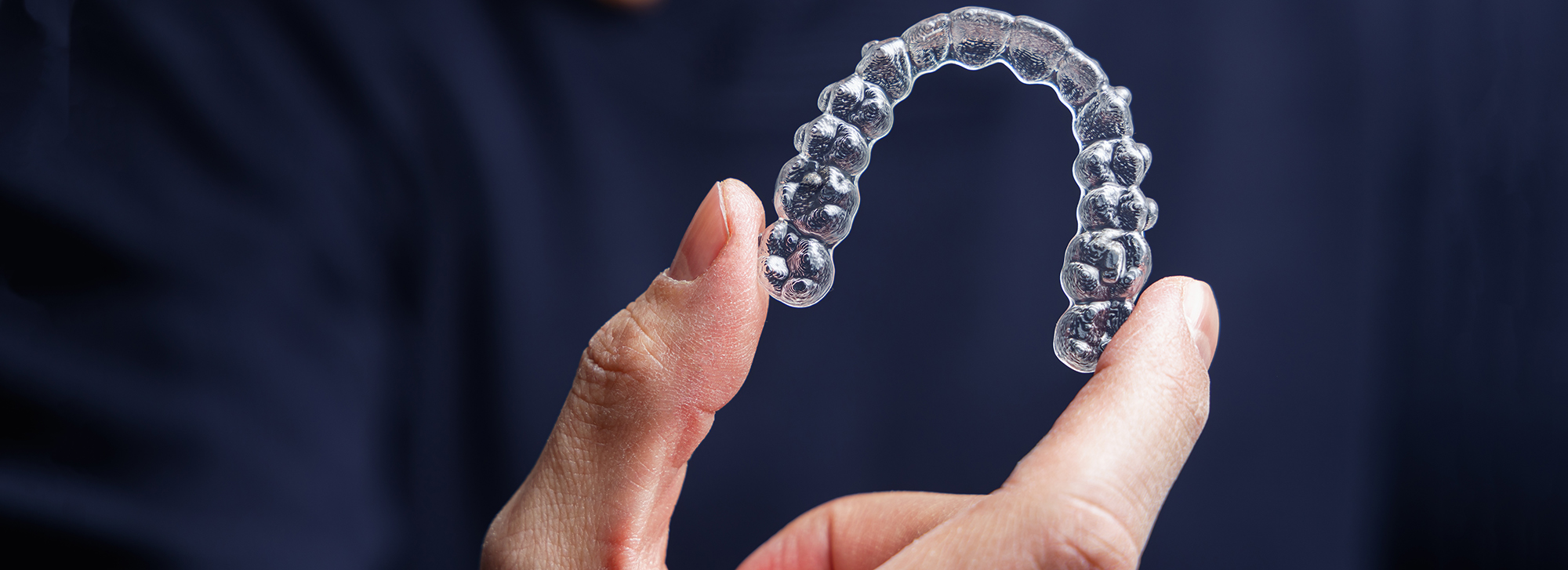 Transparente Korrekturschiene (Aligner) in der Hand
